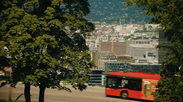 Bus driving uphill with view of Oslo